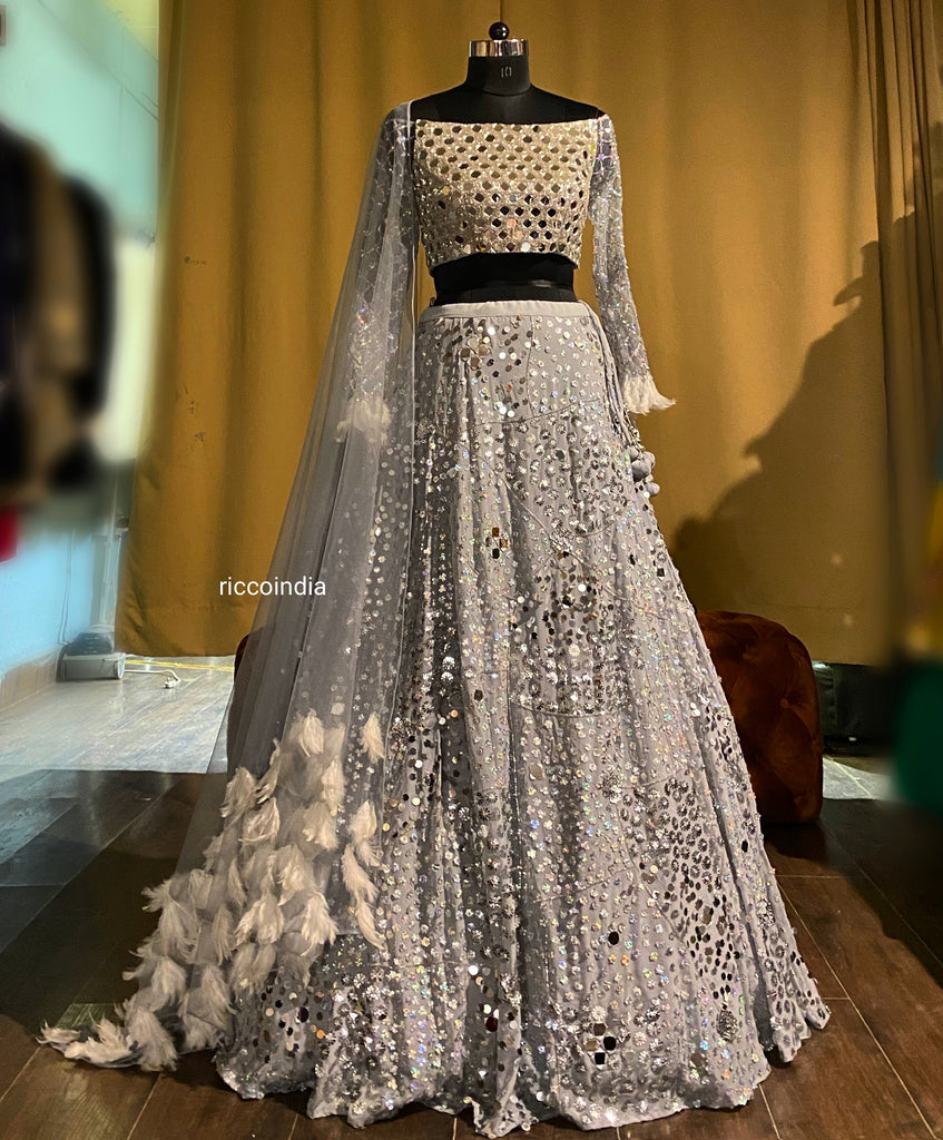 Silver lehenga with mirrorwork blouse and feather dupatta