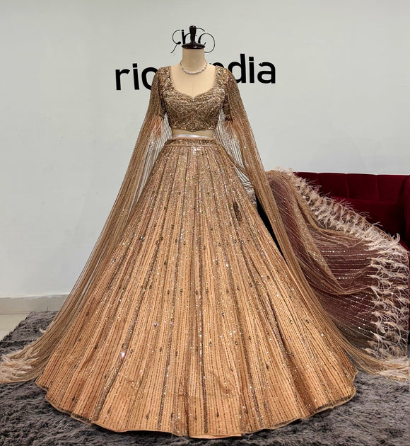 CHAMPGNE GOLD SWAROVSKI WORK LEHENGA WITH FEATHER CAPE