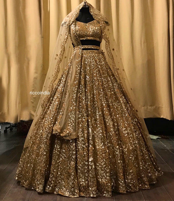 Gold bridal lehenga with heavy flared bottom and two dupattas