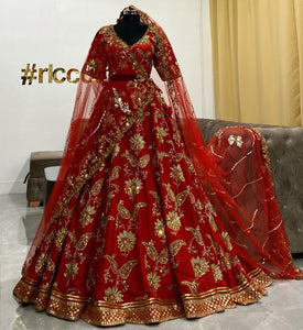 Flared red lehenga with a heavy embroidered veil