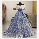 Pastel blue gown with white beadwork and feathers and a sparkly removable train