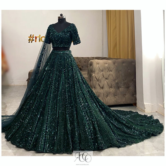 Emerald green train lehenga with intricate sequins and cut Dana work